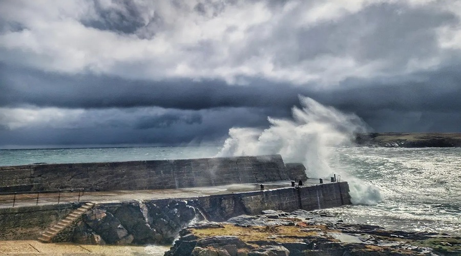 Stormy sky with waves crashing over the harbour at Port of Ness, Isle of Lewis